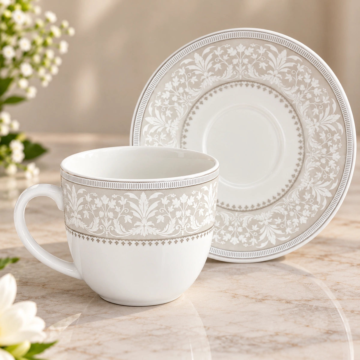 Close-up of the silver baroque scroll design on the porcelain tea cup