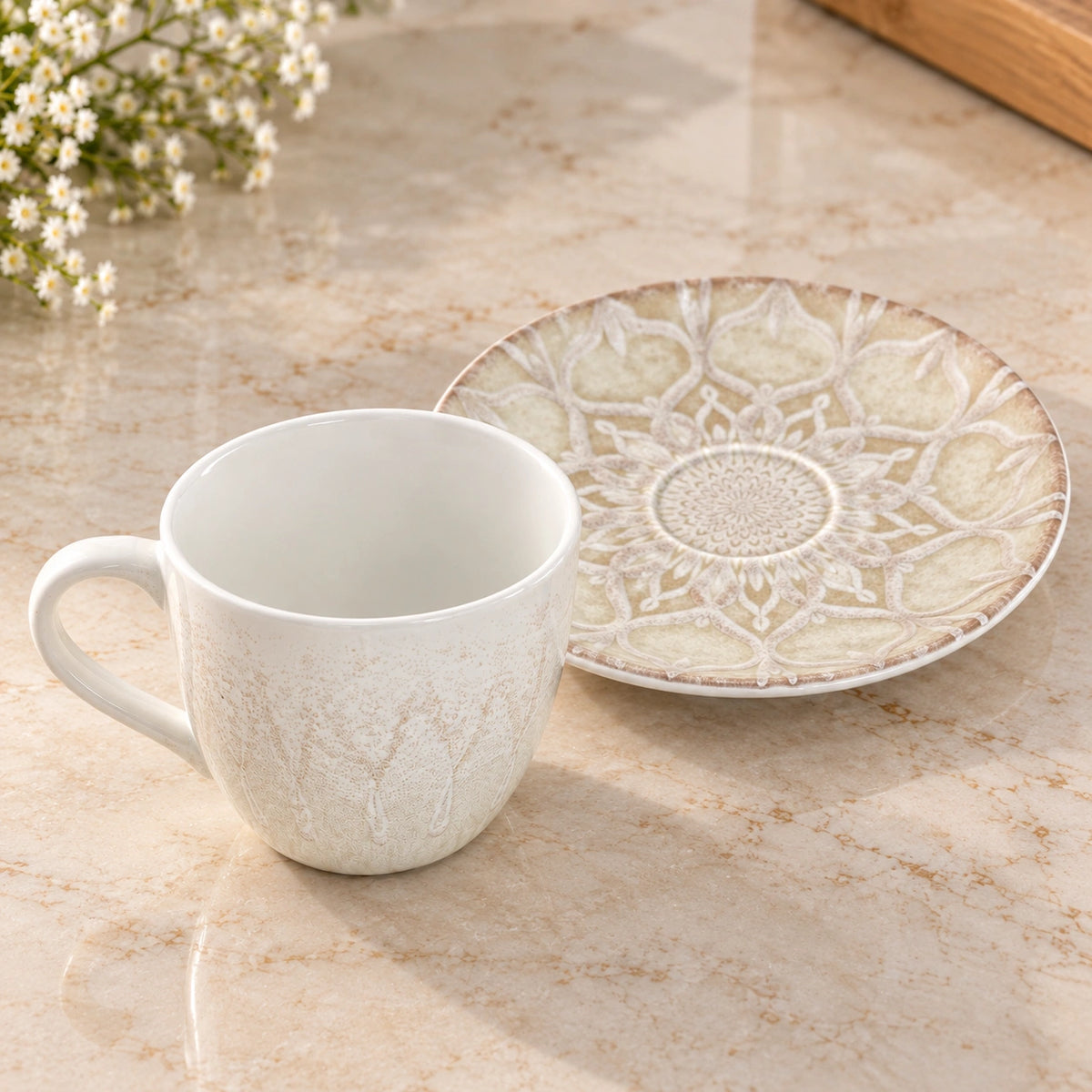Ivory Mandala embossed tea cup shown from the side with its handle